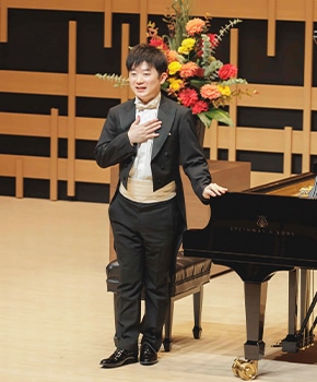 演奏後、胸に手を当ててお辞儀するピアニスト