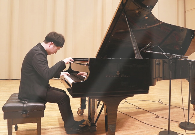 ステージでSTEINWAYのグランドピアノを演奏するピアニスト