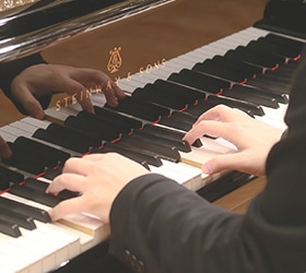 STEINWAY & SONSのグランドピアノを演奏する手元のクローズアップ